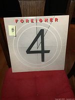 Front cover of the album showing the band name 'Foreigner' in red text at top, large black number 4 in center on light grey background with circular design.