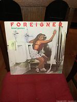 Front cover artwork of Foreigner 'Head Games' vinyl LP album showing a woman in a bathroom setting.