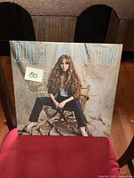Front cover of the Juice Newton LP record album titled "Juice," showing the artist sitting on a folding wooden chair in front of a beige fabric backdrop.