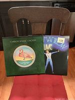 Two vinyl album cover fronts shown, Christopher Cross with flamingo illustration, and Barry Manilow Live with male singer and text.
