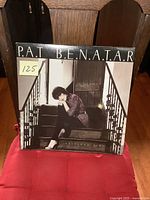 Front cover of Pat Benatar's Precious Time vinyl LP album showing Pat sitting on stairs in black and white.