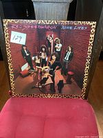 Front cover of REO Speedwagon Nine Lives album showing band members and cover art with leopard border