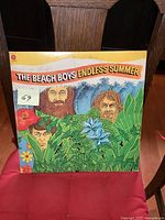 Front cover of The Beach Boys Endless Summer vinyl LP showing colorful illustrated cover art with band member caricatures and tropical theme.