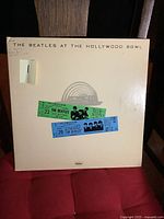 Front cover of The Beatles At The Hollywood Bowl vinyl LP album with vintage concert ticket stubs affixed.