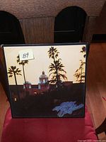 Front cover of the Hotel California LP with palm trees and hotel at dusk.