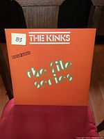 Front cover of The Kinks 'The File Series' double LP album, orange with green and white text, minor wear visible.