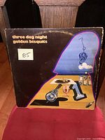 Front of the album cover with artwork and title Three Dog Night Golden Bisquits