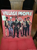 Front cover of Village People Macho Man album featuring the band members in iconic costumes standing in a row, signed with a green sticker marked '20'