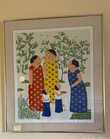 Framed lithograph showing three adult women in red, yellow, and blue dresses with two children in garden scene.