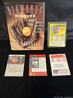 Photo of the book cover and four Barry Bonds baseball cards laid out with the backs of the cards visible showing player stats.