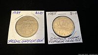 Photo showing 1984 Jacques Cartier coin and 1985 Voyageur Canoe coin in protective holders with handwritten labeling.