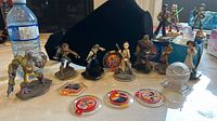 View showing Disney Infinity 3.0 figures including Frostbite, Rey, Kylo Ren, and several others with game discs in front.