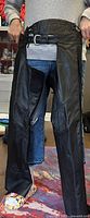 Front view of black leather Harley-Davidson ladies chaps showing adjustable waist belt and lining.