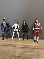 Front view of four Marvel Legends figures showing Taskmaster, Black Widow in white snow suit, Black Widow in black stealth suit, and Red Guardian in red and white suit.