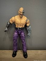 Front view of the Absorbing Man figure showing muscular torso with textured arms and purple striped pants.