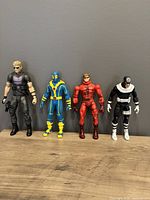 Front view of four Marvel action figures displayed against gray background, from left Hawkeye, Deadpool, Daredevil, Bullseye
