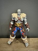Front view of Korg Build-A-Figure showing full body with detailed rocky texture, costume including fur shoulder pads, leather straps, and pants with knee guards.