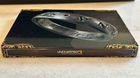 Front spine of the Uncharted 3 Drake's Deception tin box with embossed ring design.