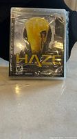 Front view of the PlayStation 3 game Haze case sealed in factory plastic wrap, showing cover art and original condition.