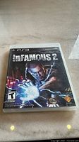 Front cover of the PS3 game InFamous 2 showing main character and title.