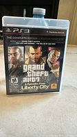 Front cover of the game case showing the three main characters and game title for Grand Theft Auto IV & Episodes From Liberty City Complete Edition for PlayStation 3.