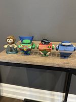 Four figurines lined up showing front and side views: Funko Mystery Mini Aquaman on far left, followed by three square-bloc style DC Blammoids: Martian Manhunter, Robin, Darkseid