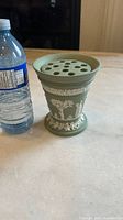 Wedgwood jasperware sage green flower vase with removable frog flower arranger next to a water bottle for scale