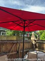 Photo focusing on the vibrant red umbrella open outdoors showing structure and coverage.