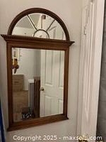 Full view of the wall mirror showing the wooden frame, beveled rectangular lower mirror, and leaded half-moon top.