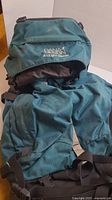 Front view of large Dana Design hiking backpack in blue and black with logo visible