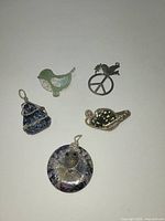 Six assorted pendants arranged on a flat surface showing variety and detailing