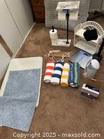 Photo showing shower curtains, paper holder, towels, rugs, and other assorted bathroom accessories on carpet
