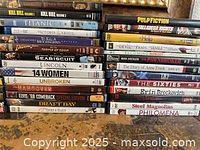 DVD collection stacked and showing titles on spines including Kill Bill, Titanic, Unbroken, Seabiscuit, Erin Brockovich, Philomena.