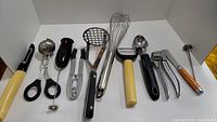 Wide view of all kitchen tools arranged in a row showing different types and sizes of utensils