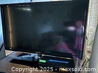 Samsung 32-inch flat screen TV shown powered off on stand