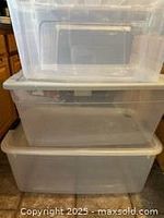 Two clear plastic storage bins stacked showing size difference and lids.