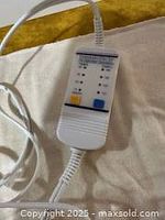 Close-up image of the wired controller attached to the heating pad showing temperature settings and indicators