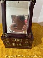 Front view of the jewelry chest with opened lid showing mirror and drawer area.