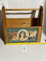 Front view of the wooden seed selling box with logo and floral artwork on front panel, measuring about 12 inches wide.