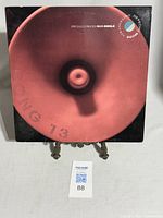 Front cover of the vinyl record sleeve showing a blurred red object with text indicating a specially priced maxi-single by Depeche Mode.