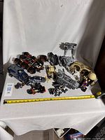 Full view of LEGO assembled models and parts on a white surface with measuring tape