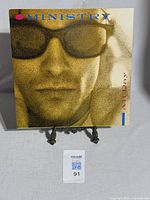 Front cover of Ministry 12" vinyl single showing grainy close-up of a man wearing sunglasses with the title 'All Day'