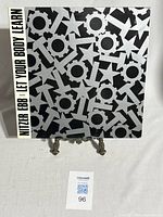 Front cover of Nitzer Ebb vinyl single 'Let Your Body Learn' showing black and white abstract geometric pattern with bold text on side.