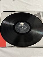 Photo of vinyl record side 1 on top of sleeve showing Geffen Records label and visible grooves.