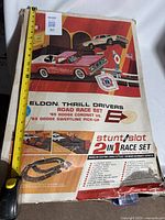 Box cover showing vintage Eldon Thrill Drivers Road Race Set featuring Dodge Coronet vs Dodge Sweptline Pick-Up and stunt or slot 2-in-1 race set graphics.
