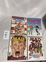 Four Mad Magazine comics arranged together, showing distinct colorful covers.