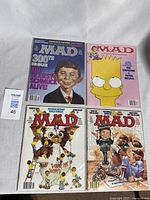 Four vintage Mad magazines laid out, showing covers with cartoon parodies including issue 300.