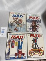 Four Mad Magazine comic books arranged side by side showing front covers.