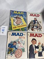 Lot of four vintage Mad Magazine comic books displayed together on a surface