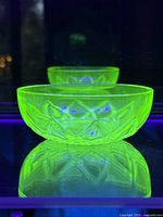 Uranium Vaseline glass dish bowl glowing bright green under ultraviolet light showing its distinctive fluorescence